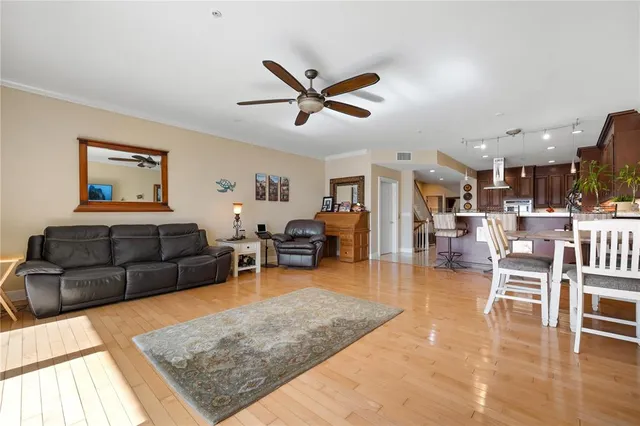 a living room with furniture and a dining table with wooden floor