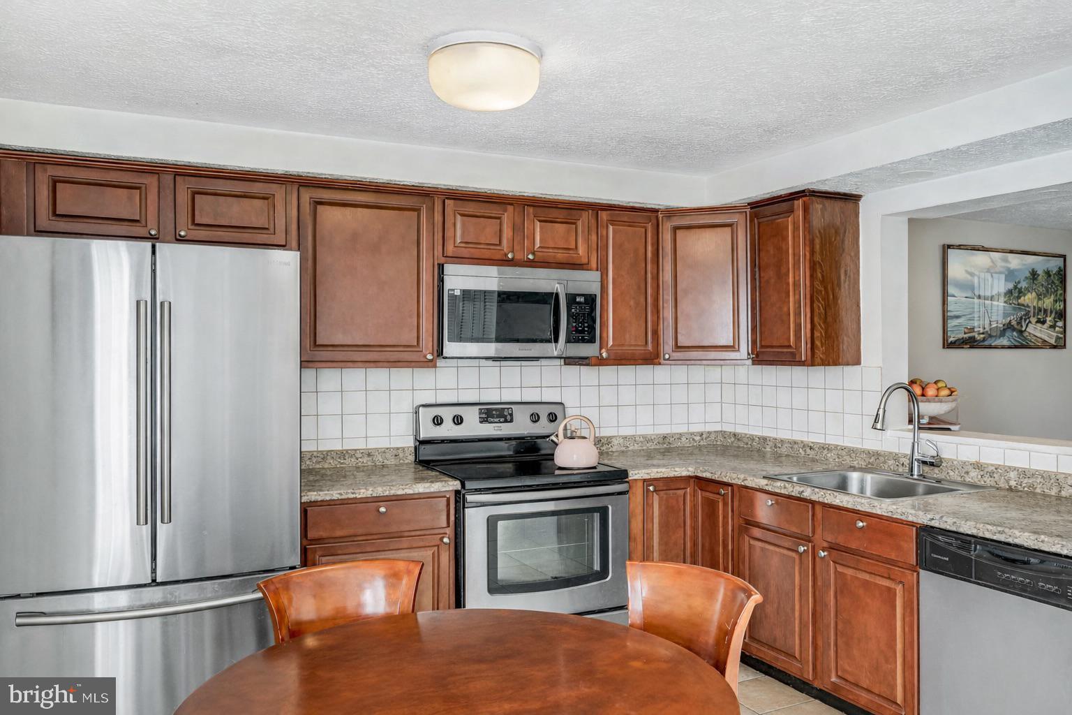 7467 Lone Star Road Lorton, VA 22079 - Photo 3 of 21 a kitchen with stainless steel appliances granite countertop a refrigerator stove top oven and sink