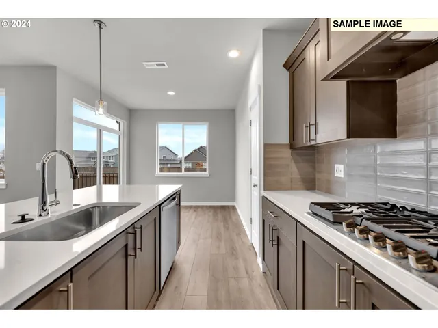 a kitchen that has a sink wooden cabinets and stainless steel appliances