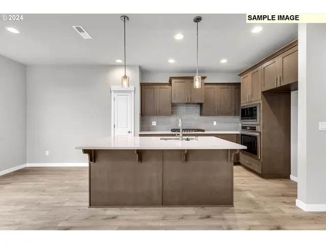 a kitchen with kitchen island a sink stainless steel appliances and cabinets
