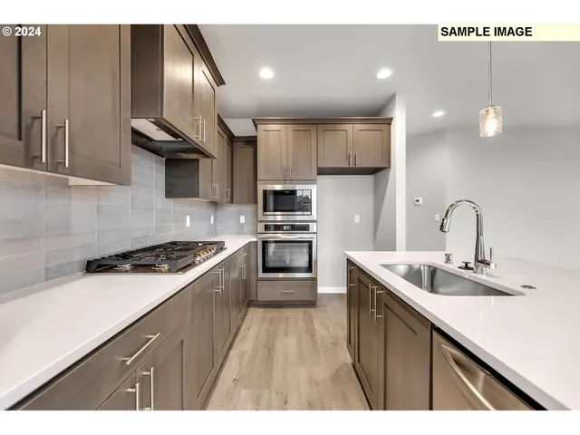 a kitchen with kitchen island granite countertop a sink stainless steel appliances and cabinets