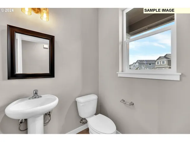 a bathroom with a toilet a sink and mirror