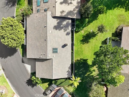 an aerial view of a residential house with a yard and garden