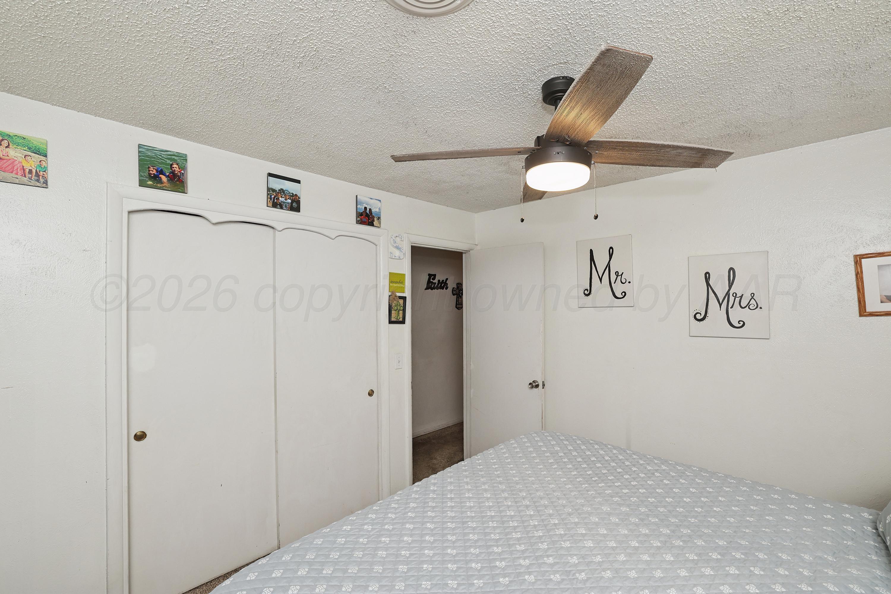 2321 Bell Street Amarillo, TX 79106 - Photo 11 of 24 a bedroom with a bed and a chandelier