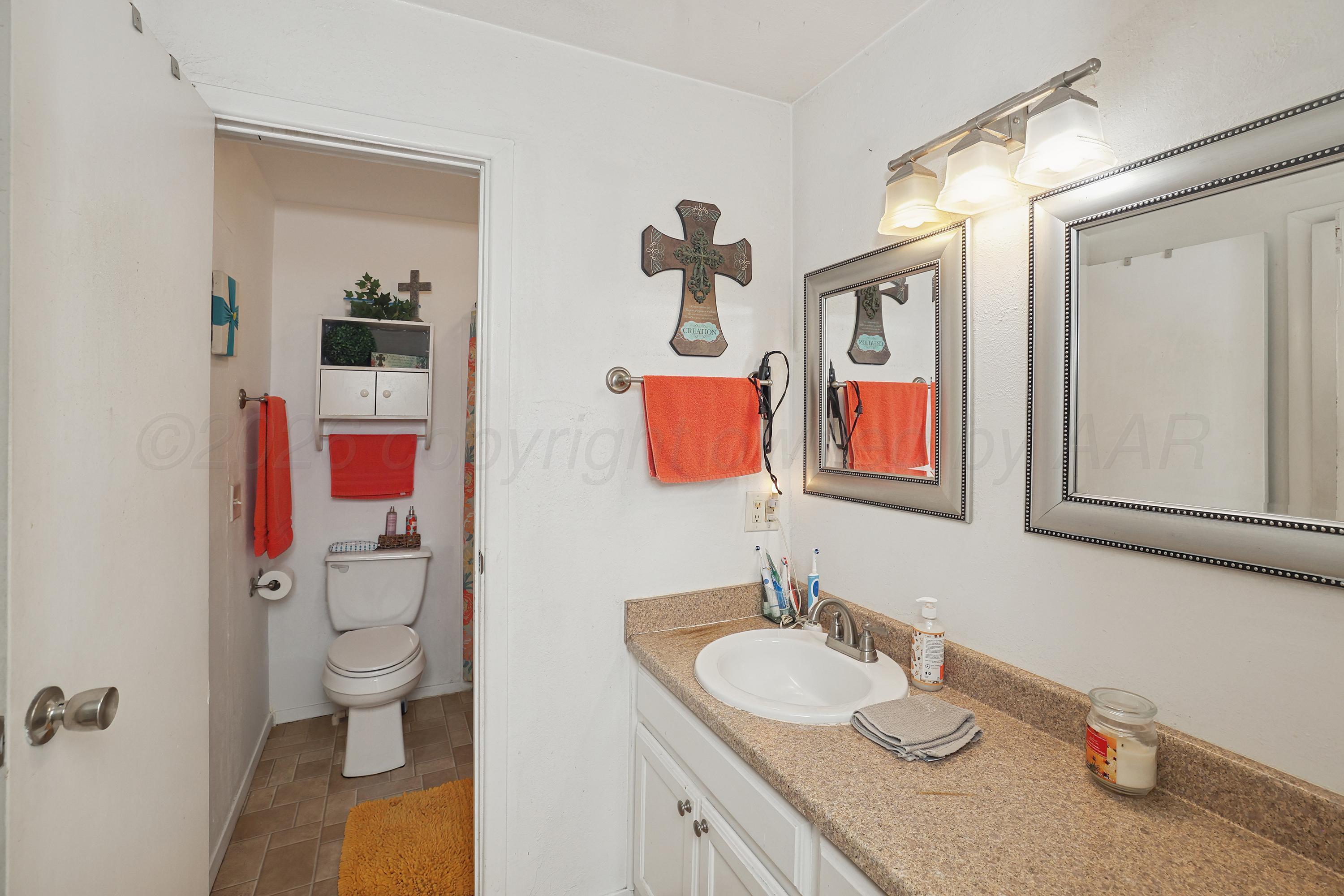 2321 Bell Street Amarillo, TX 79106 - Photo 16 of 24 a bathroom with a granite countertop sink and a mirror