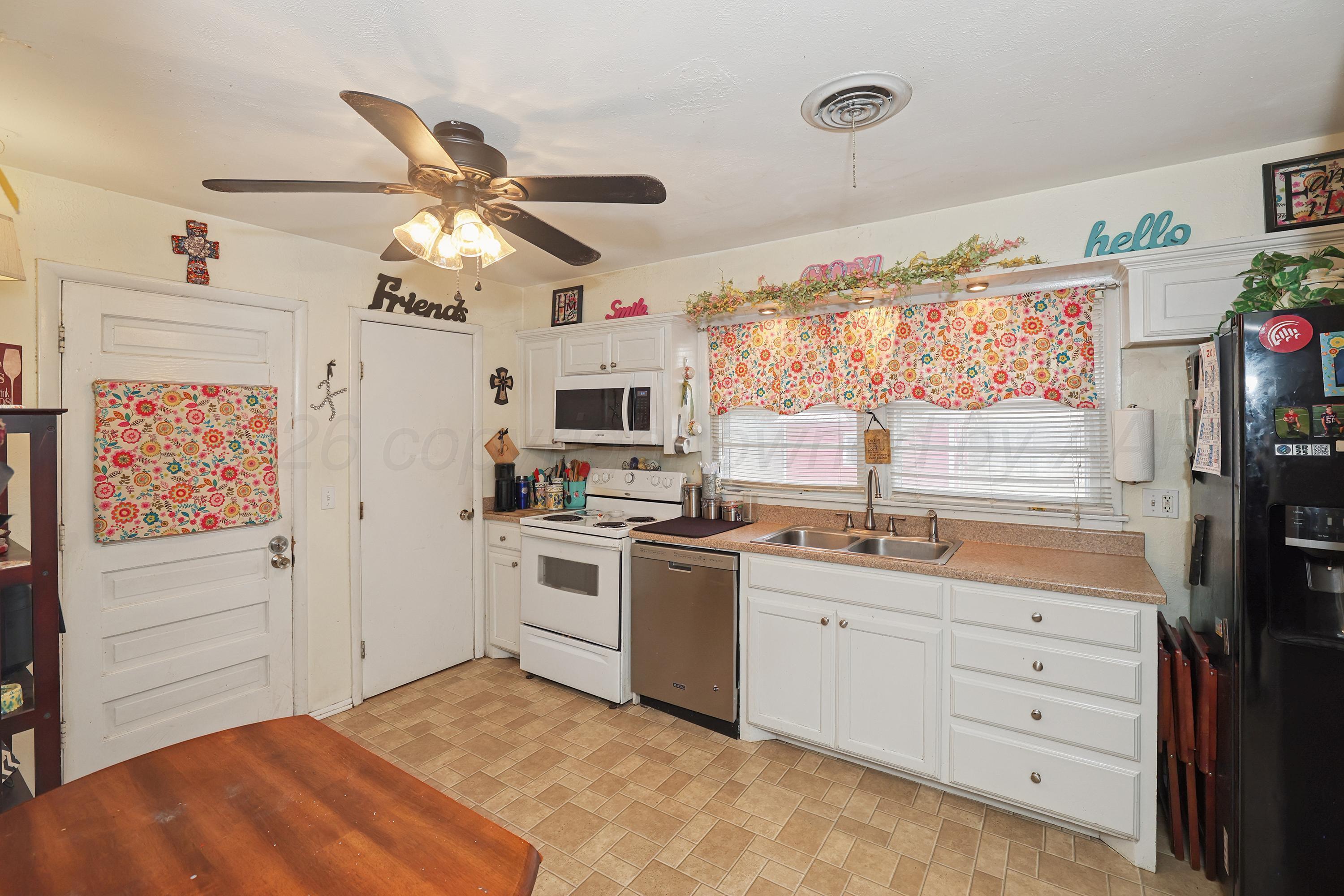 2321 Bell Street Amarillo, TX 79106 - Photo 6 of 24 a kitchen with a refrigerator stove and white cabinets