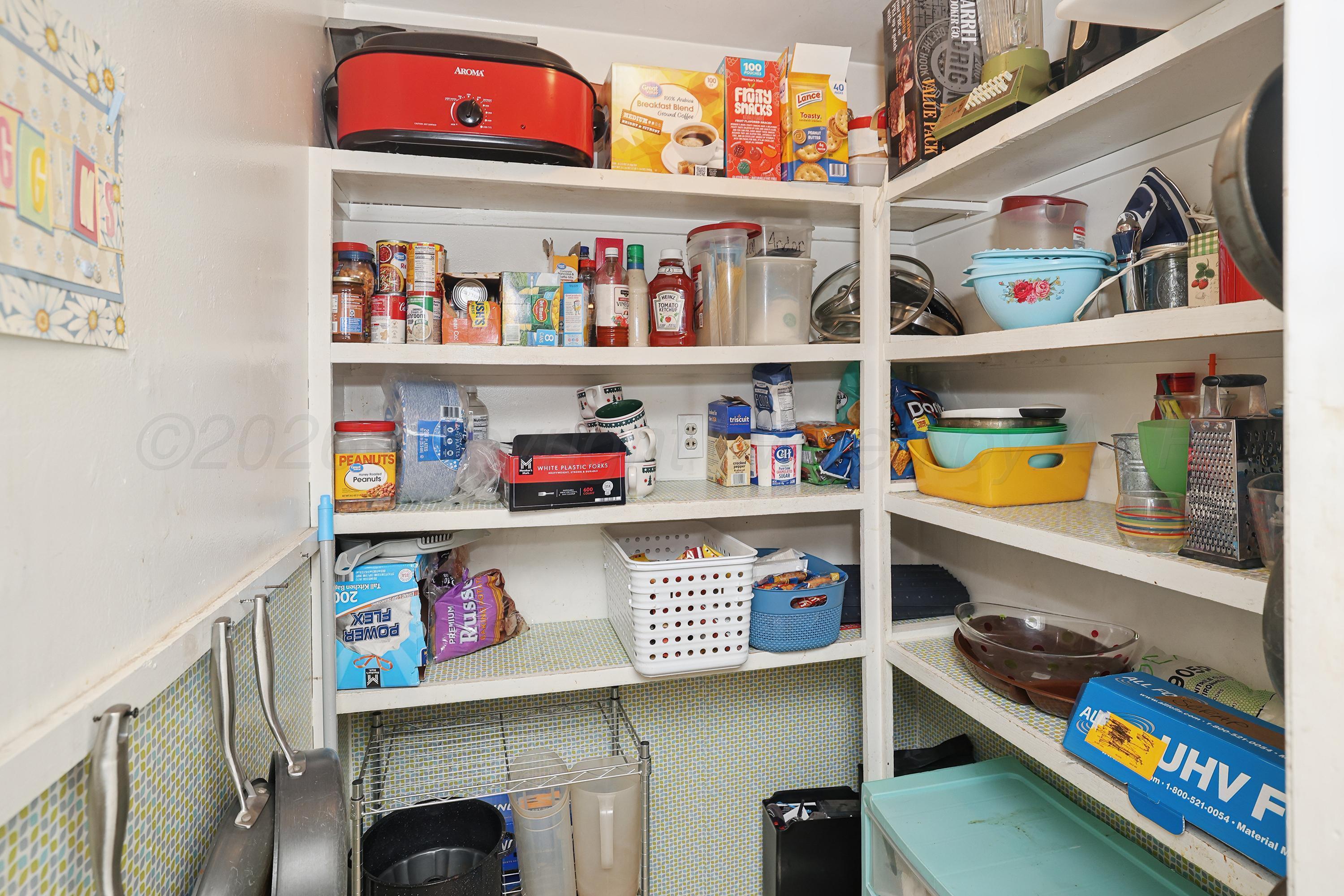 2321 Bell Street Amarillo, TX 79106 - Photo 7 of 24 a store room with lots of clutter and white cabinets