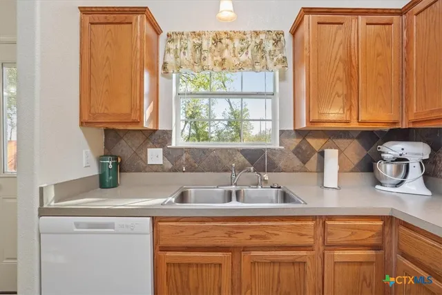 a kitchen with stainless steel appliances granite countertop a sink a refrigerator and cabinets