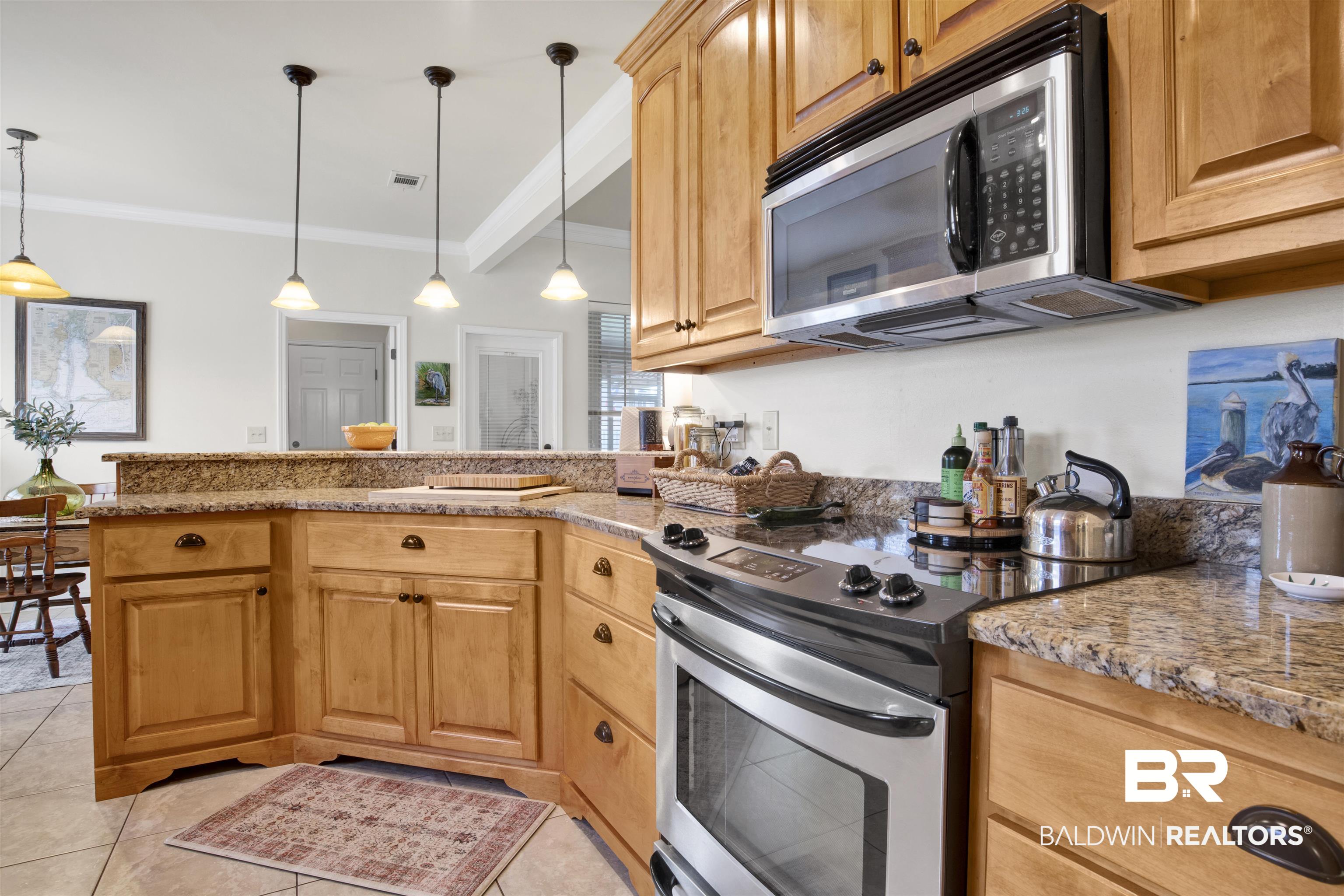 10368 Gayfer Rd Extension Fairhope, AL 36532 - Photo 8 of 43 Kitchen featuring wood cabinetry, stone countertops, stainless steel appliances, and tile flooring