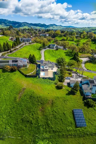 an aerial view of a house with a garden and swimming pool