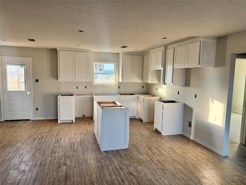 1017 Morgan Court Springtown, TX 76082 - Photo 2 of 6 a large white kitchen with a white stove top oven and white cabinets