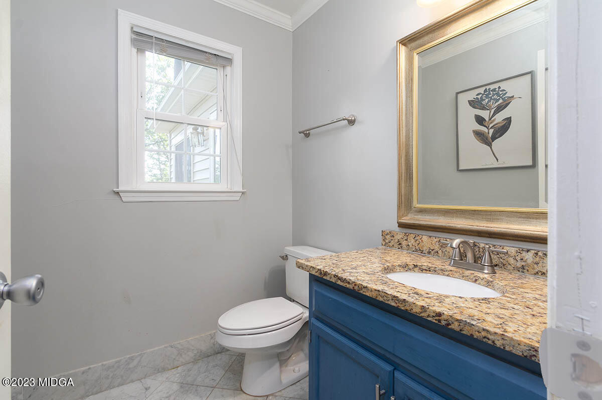 173 Old Ridge Road Macon, GA 31211 - Photo 12 of 37 a bathroom with a granite countertop sink a toilet and a window