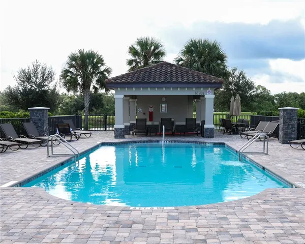 an aerial view of residential houses with outdoor space and ocean view