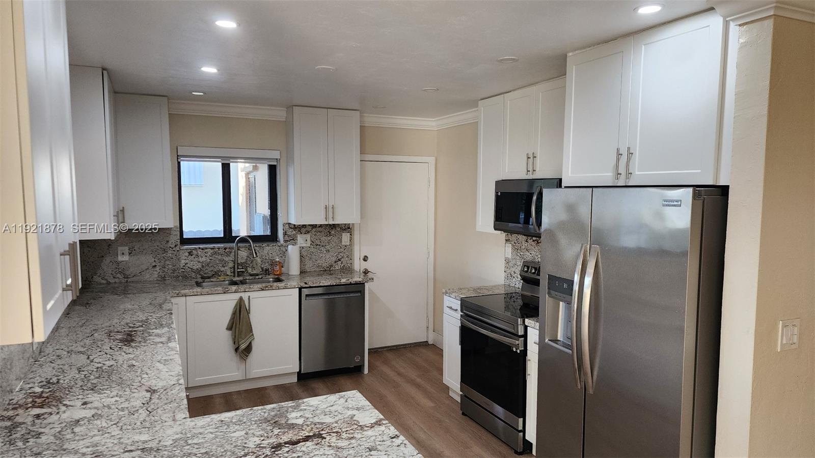 8010 Southwest 16th Street, Unit 8010 Miami, FL 33155 - Photo 13 of 33 a kitchen with stainless steel appliances granite countertop a refrigerator and a stove