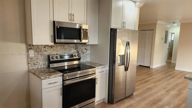 a kitchen with stainless steel appliances granite countertop a sink stove and refrigerator