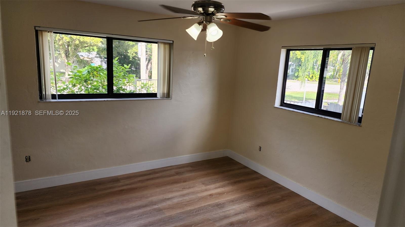 8010 Southwest 16th Street, Unit 8010 Miami, FL 33155 - Photo 22 of 33 a view of an empty room with wooden floor and a window