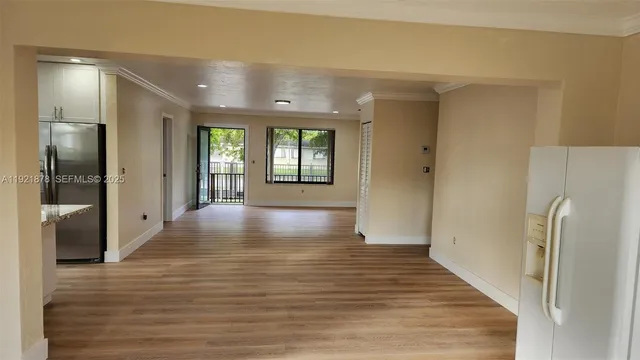 a view of a hallway with wooden floor and a living room