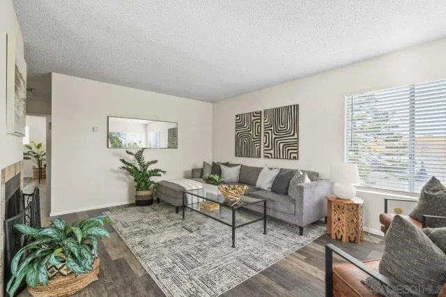 a living room with furniture dining table a fireplace and a potted plant