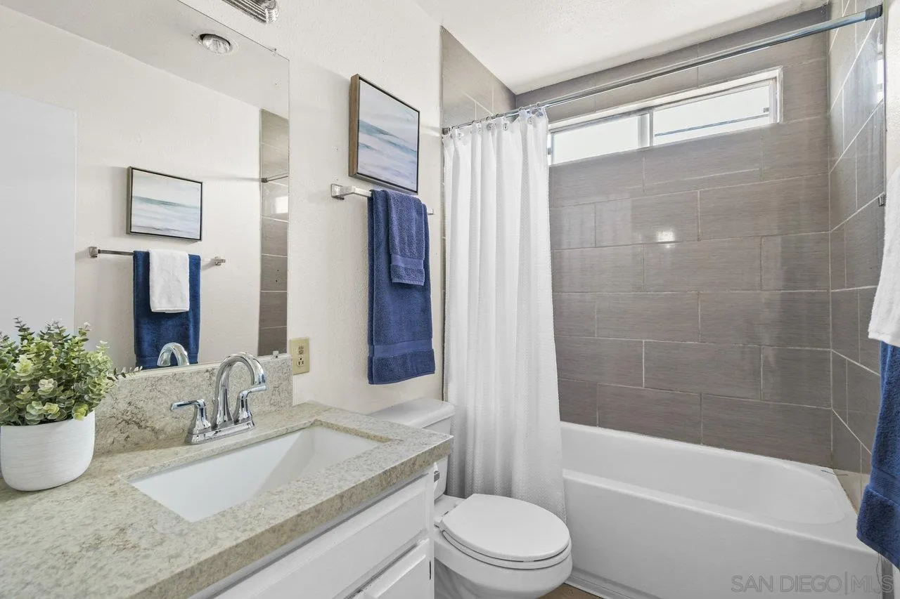 4614-4616 Larkspur Street San Diego, CA 92107 - Photo 37 of 51 a bathroom with a granite countertop sink toilet mirror and shower