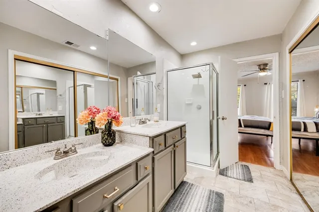 a spacious bathroom with a granite countertop sink mirror and shower