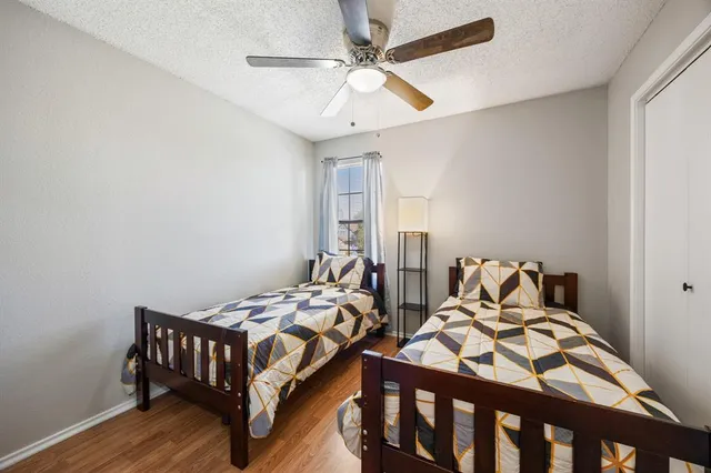 a bedroom with two beds and wooden floor