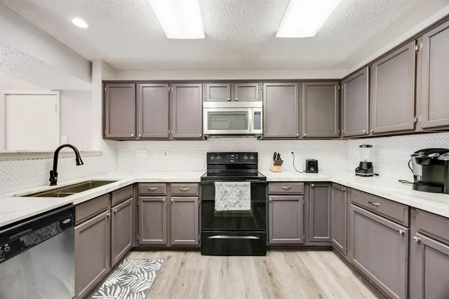 a kitchen with a sink cabinets and appliances