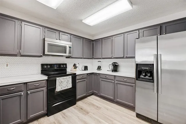a kitchen with cabinets stainless steel appliances and a counter space