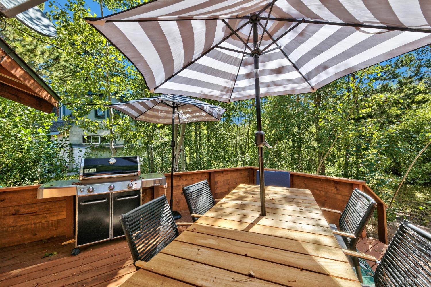 3865 Beach Road South Lake Tahoe, CA 96150 - Photo 24 of 35 a view of a patio with table and chairs under an umbrella with a small yard