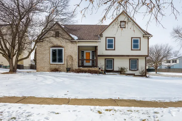 a front view of a house with a yard covered in snow