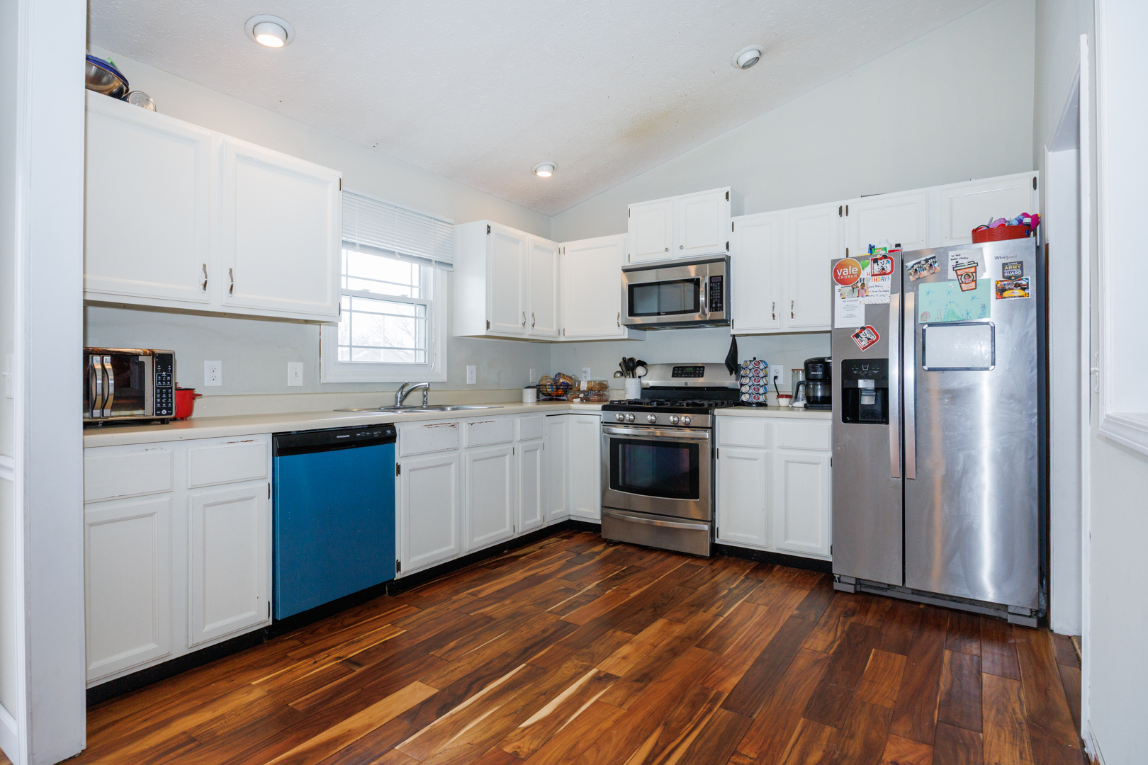 205 North Blair Drive Normal, IL 61761 - Photo 11 of 38 a kitchen with granite countertop wooden floors stainless steel appliances and white cabinets