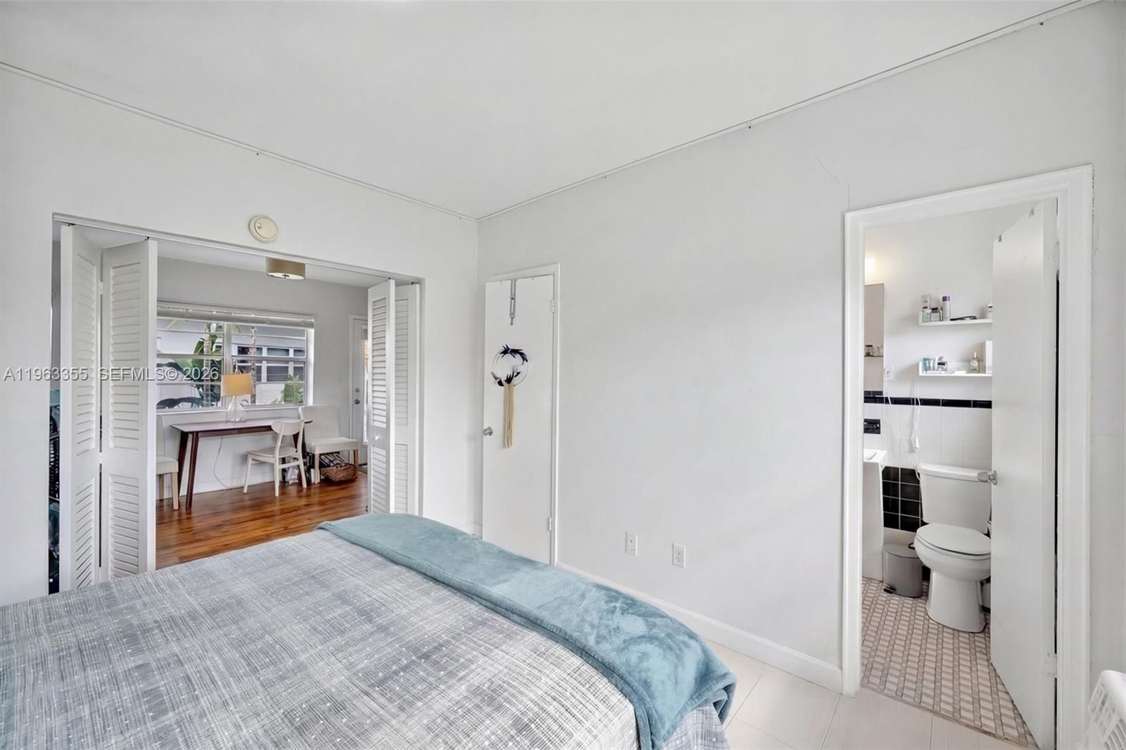 1925 Washington Avenue, Unit 21 Miami Beach, FL 33139 - Photo 5 of 16 a bedroom with a bed and a view of en suite bathroom