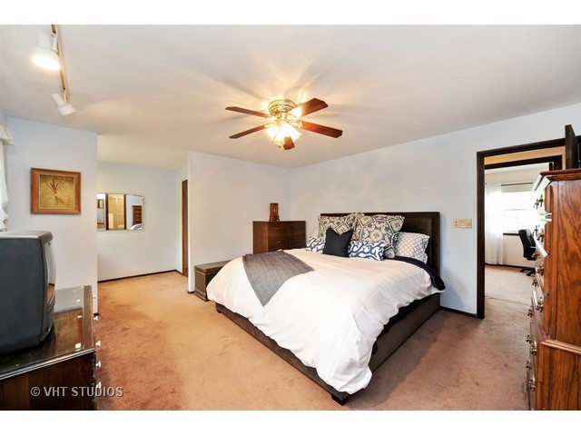 439 Weidner Road Buffalo Grove, IL 60089 - Photo 9 of 23 a bedroom with a bed and a chandelier