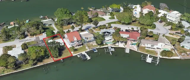 an aerial view of a city with lots of residential buildings ocean and mountain view in back