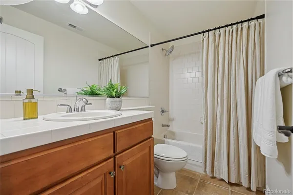 a bathroom with a granite countertop sink a toilet and shower