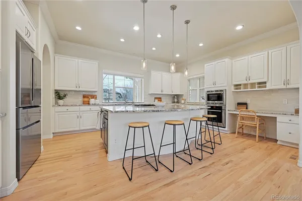 a kitchen with kitchen island granite countertop wooden floors and appliances