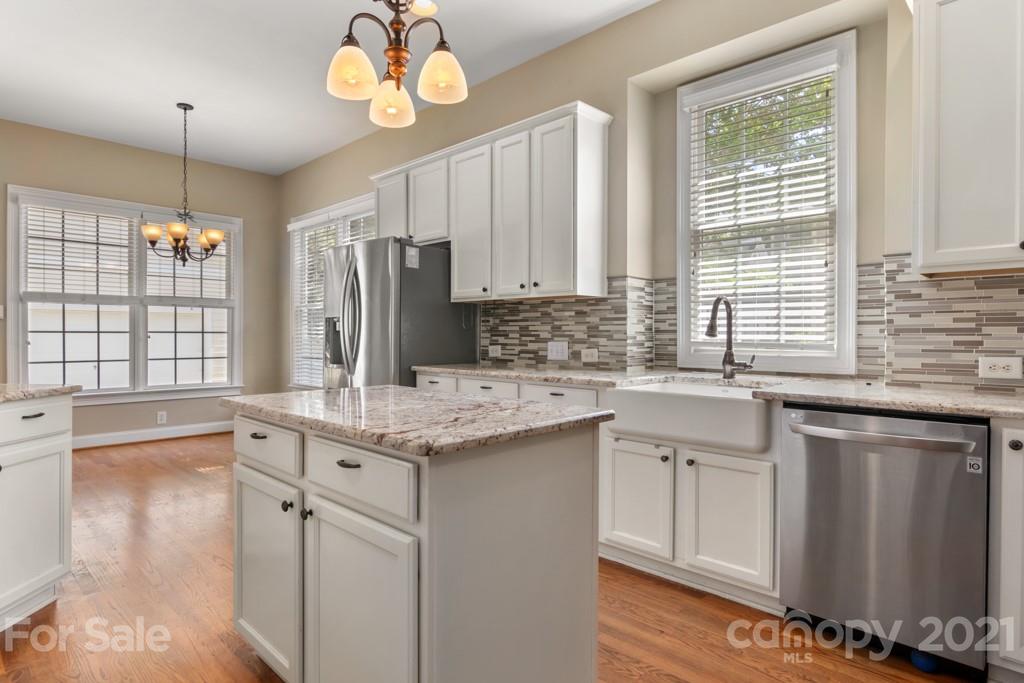 3272 Richard's Crossing, Unit 247 Fort Mill, SC 29708 - Photo 18 of 38 a kitchen with stainless steel appliances granite countertop a sink a stove a refrigerator and island with wooden floor