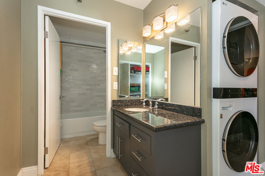 600 West 9th Street, Unit 810 Los Angeles, CA 90015 - Photo 11 of 24 a spacious bathroom with a sink a mirror a toilet and a shower