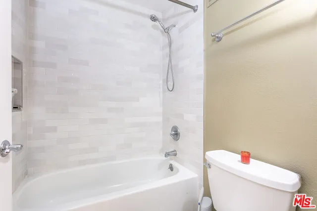 a white bath tub sitting next to a white toilet and a shower
