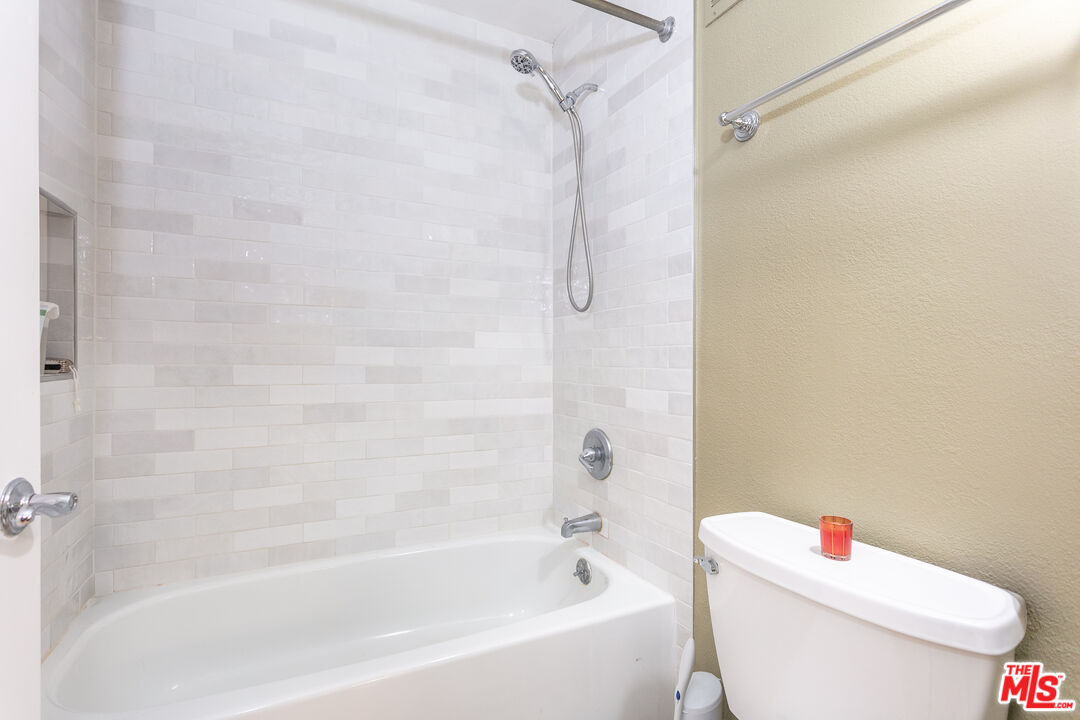 600 West 9th Street, Unit 810 Los Angeles, CA 90015 - Photo 13 of 24 a white bath tub sitting next to a white toilet and a shower