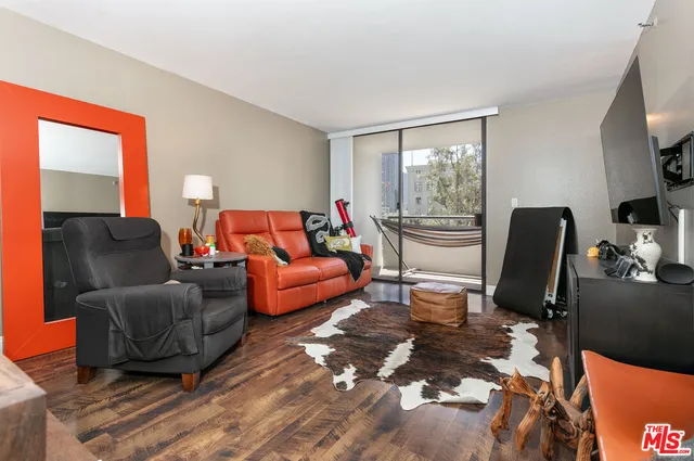a living room with furniture fireplace and a large window