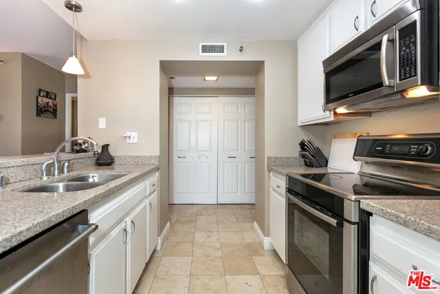 a kitchen with stainless steel appliances granite countertop a sink stove and microwave