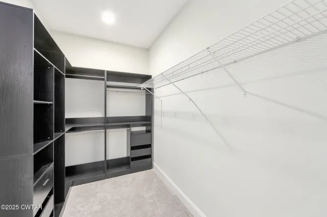 a view of walk in closet with empty racks