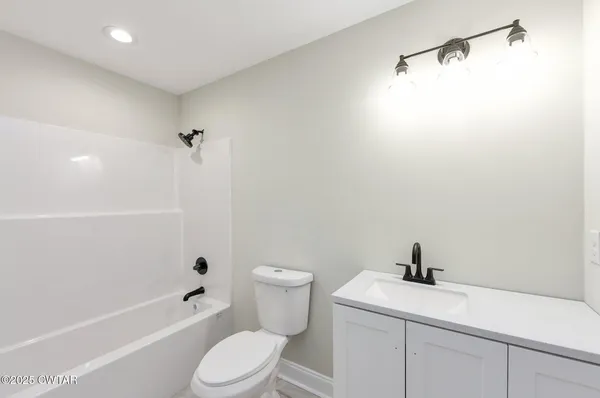 a white toilet sitting next to a bath tub