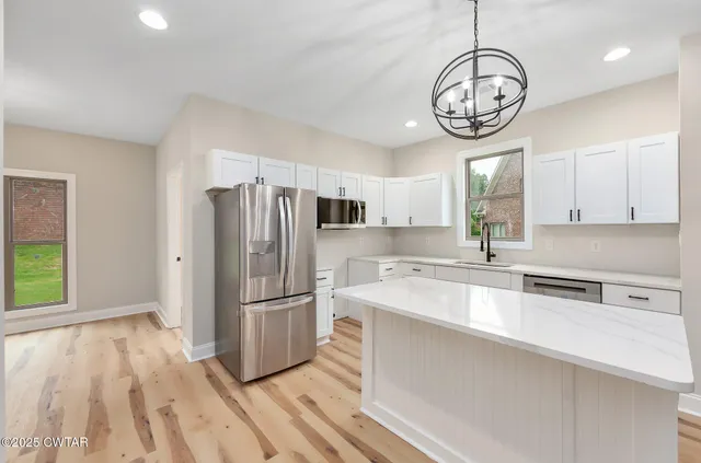 a kitchen with stainless steel appliances a large counter space a sink and cabinets