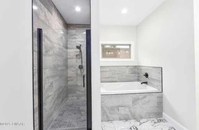 a bathroom with a bathtub and shower