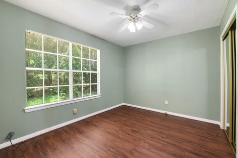 a view of a room with wooden floor and windows