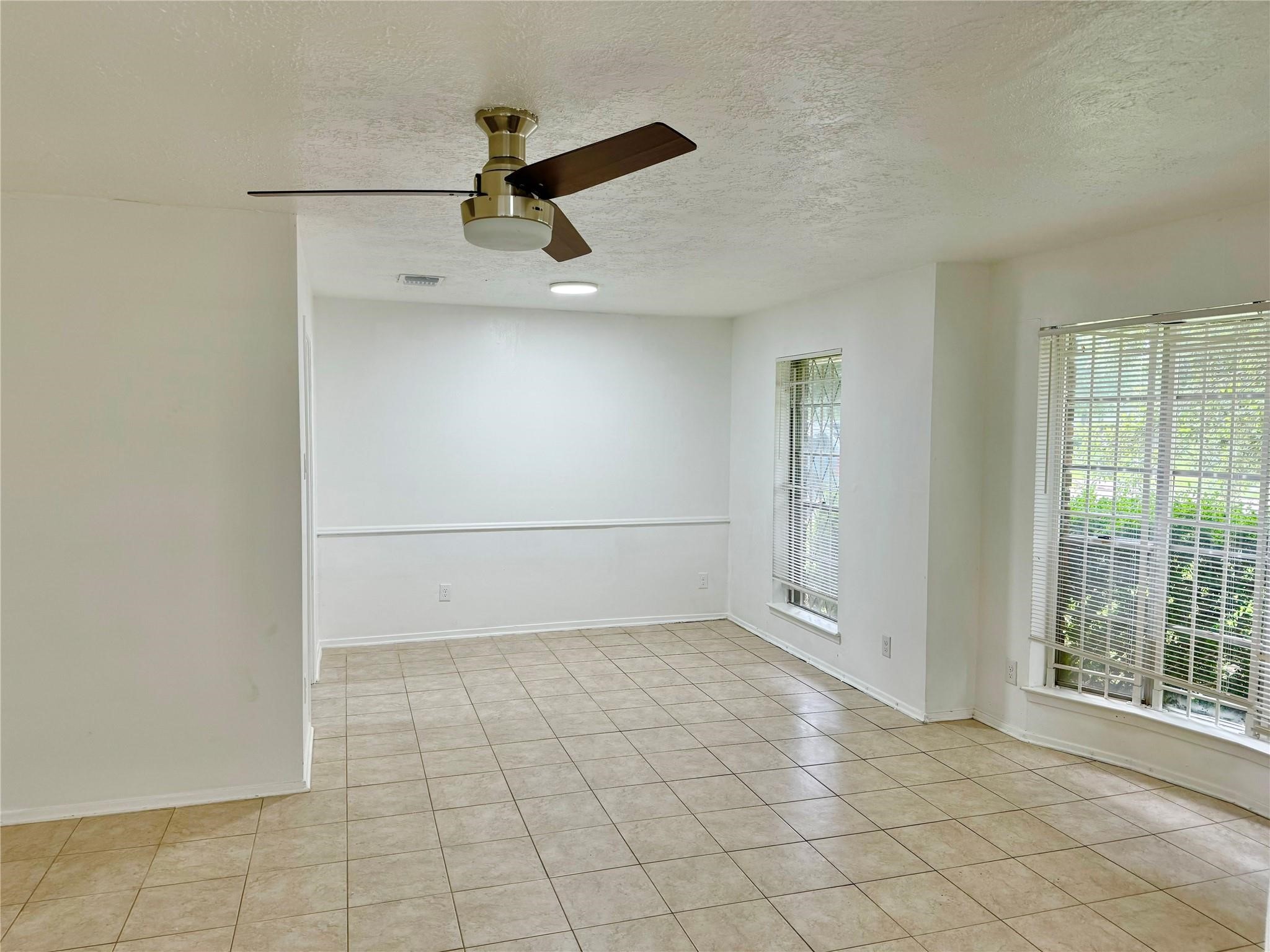 7015 Pyron Way Houston, TX 77036 - Photo 4 of 12 an empty room with windows and ceiling fan