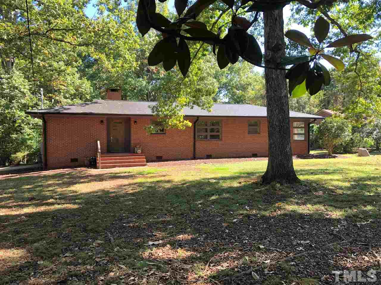 a view of a house with backyard and a tree