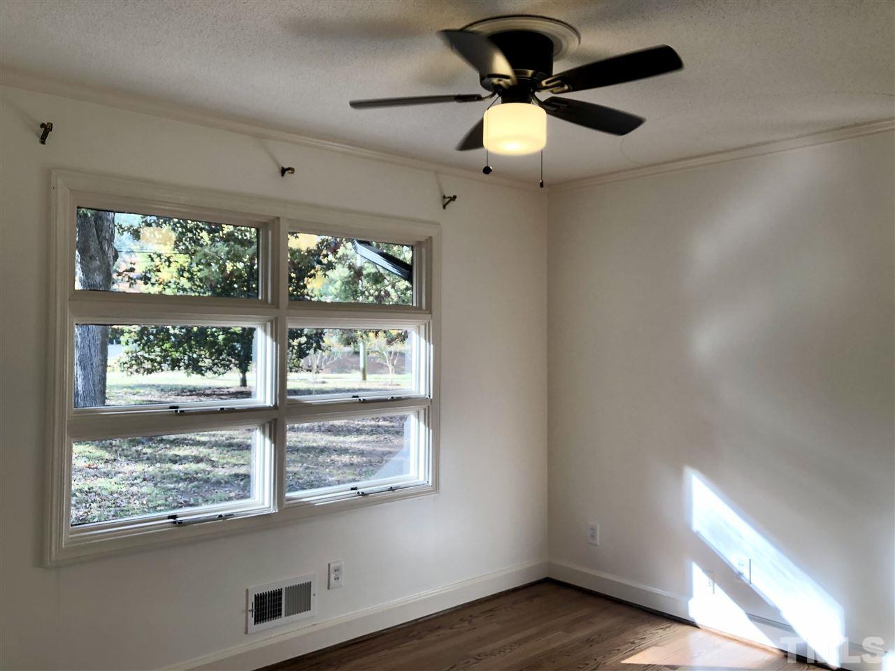 521 Buck Jones Road Raleigh, NC 27606 - Photo 11 of 30 an empty room with wooden floor fan and windows