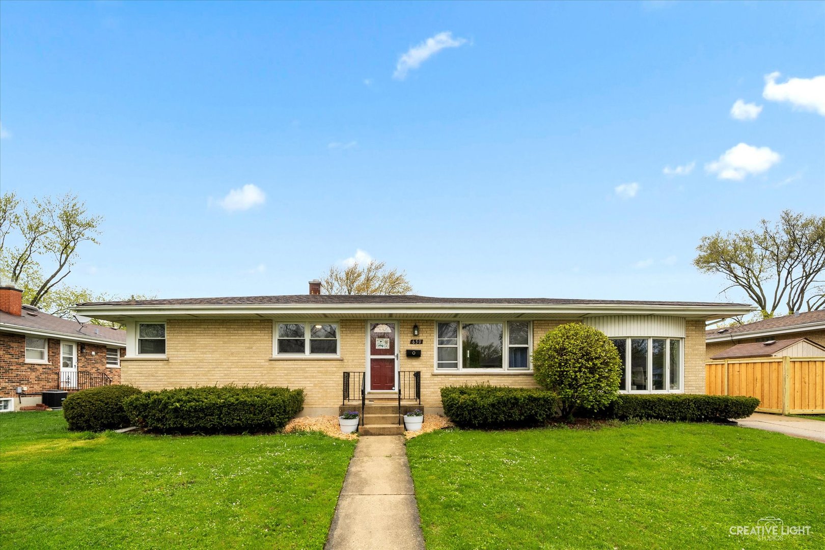 a front view of a house with a garden and yard